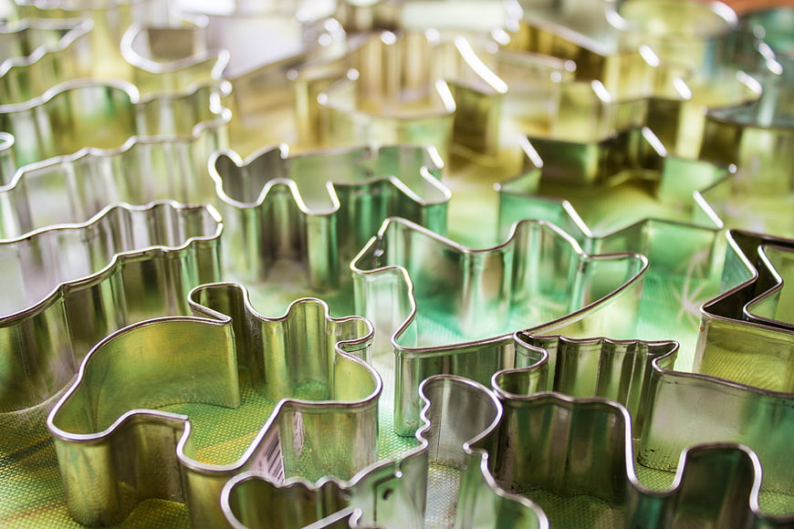 Assorted metal cookie cutters on green baking mat