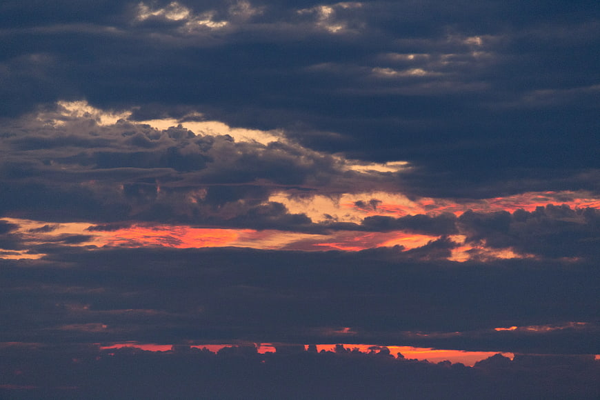 Dramatic sunset sky with vibrant orange clouds and dark blue layers