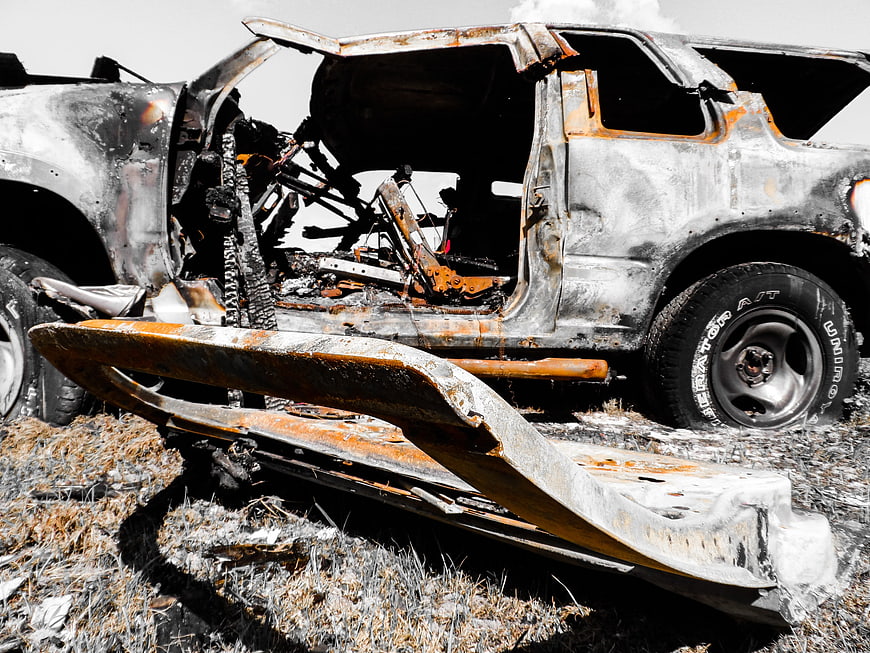 Burnt SUV Wreckage with Rusty Metal and Charred Interior