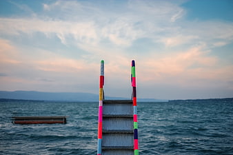 Colorful Knitted Ladder Leading to Lake at Sunset