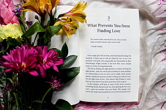 Open Book About Love with Colorful Flowers on Bed