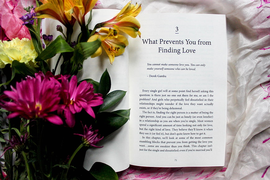 Open Book About Love with Colorful Flowers on Bed