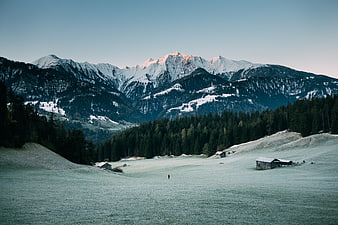 Snowy Mountain Peaks with Frosty Meadow and Wooden Cabins