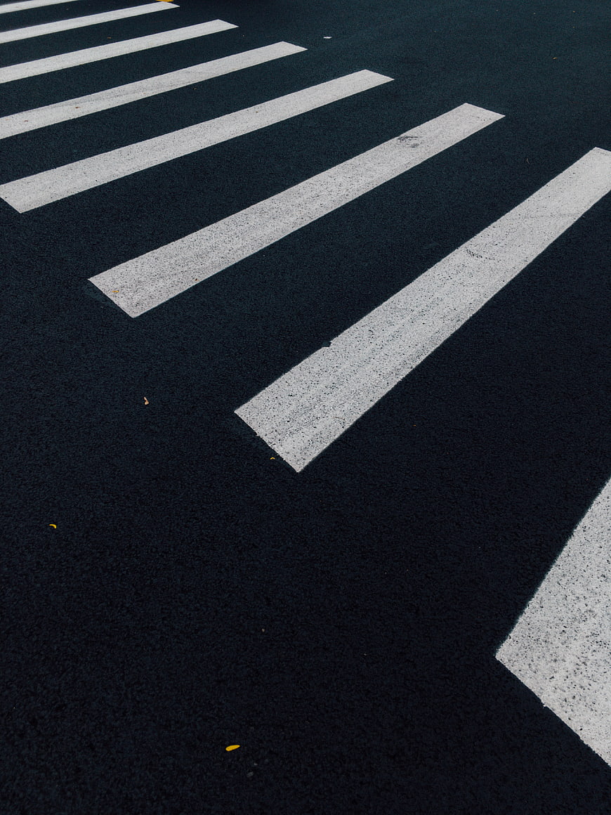 Diagonal View of White Zebra Crossing on Dark Asphalt Road