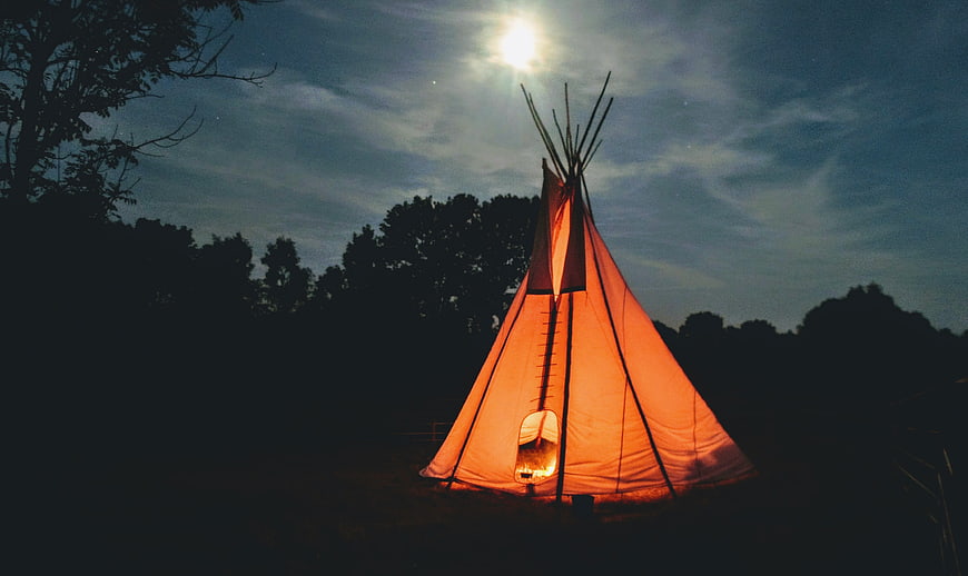 Glowing Teepee Tent Under Moonlit Night Sky