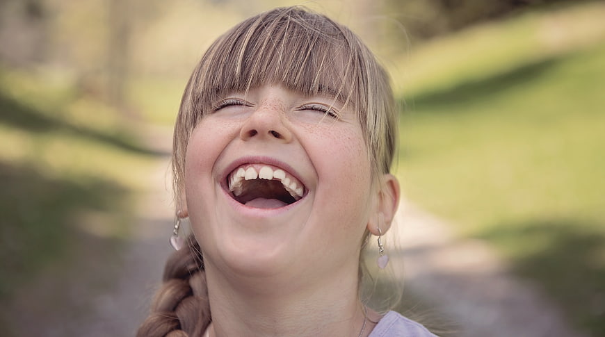 Joyful Close-Up Portrait Of Laughing Young Girl With Freckles