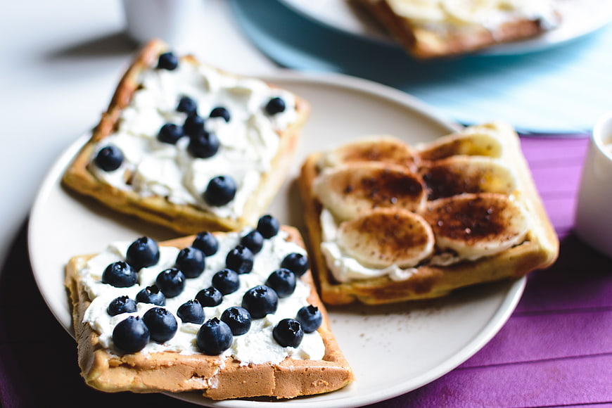 Waffles with blueberries and caramelized bananas on a plate