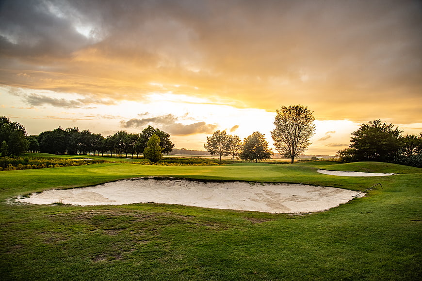 Dramatic sunset over a golf course with sand traps