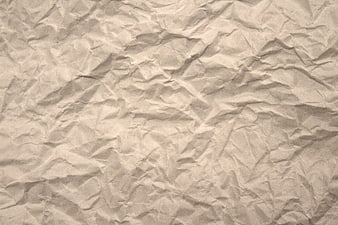 Crumpled beige paper texture background with wrinkles and folds