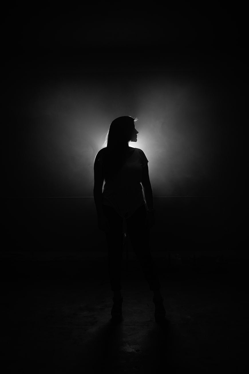 Dramatic Silhouette of Woman in Dark Room