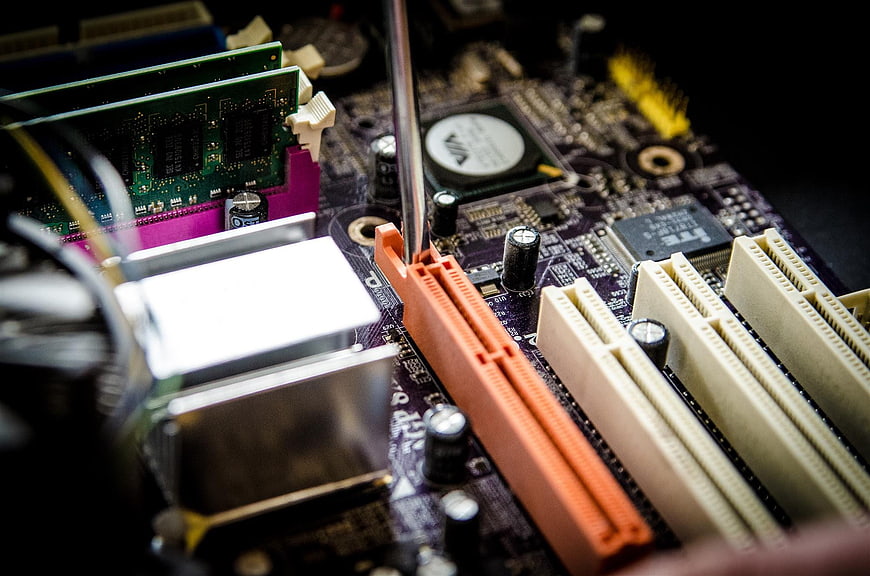 Close-up of computer motherboard repair with screwdriver
