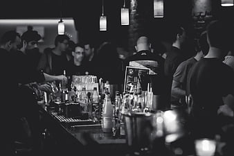 Crowded Bar Scene With Bottles And Hanging Lamps In Black And White