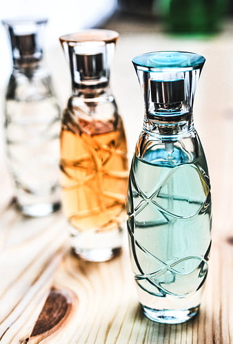 Three Glass Perfume Bottles on Wooden Surface