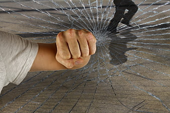 Fist Punching Through Broken Glass Window Concept