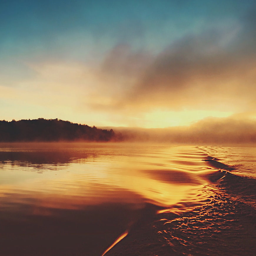 Golden Sunset Over Misty Lake with Forest Silhouette