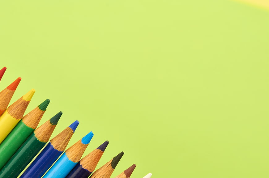 Colorful Pencils on Green Background with Copyspace