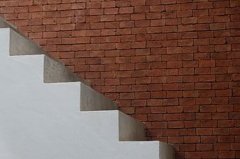 White Concrete Staircase Against Red Brick Wall