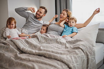 Happy family waking up together in bed