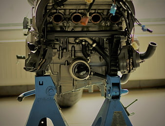 Motorcycle engine on blue stand in workshop