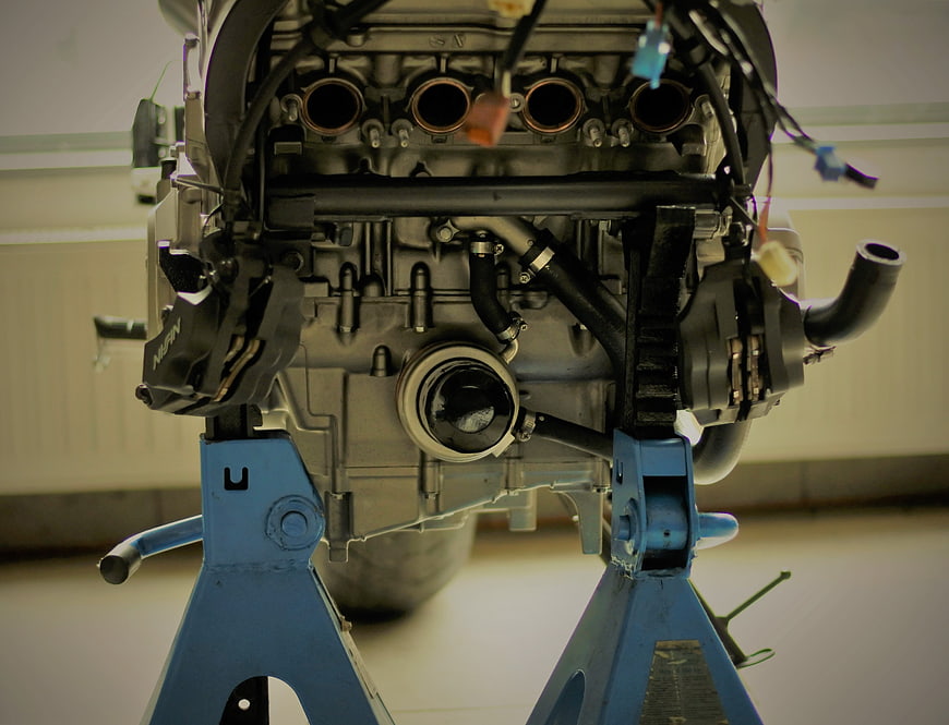 Motorcycle engine on blue stand in workshop