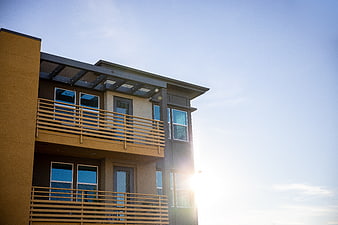 Modern Apartment Building Exterior with Balconies and Sun Flare