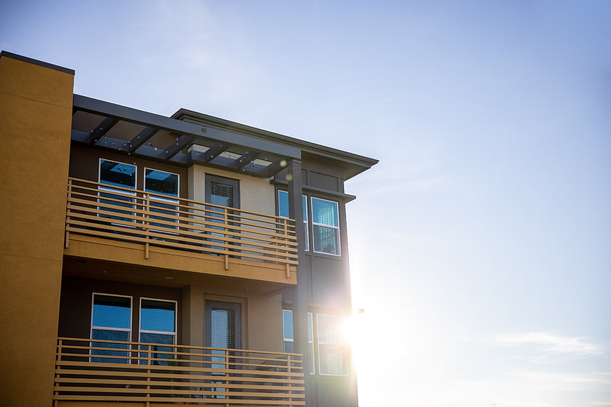 Modern Apartment Building Exterior with Balconies and Sun Flare