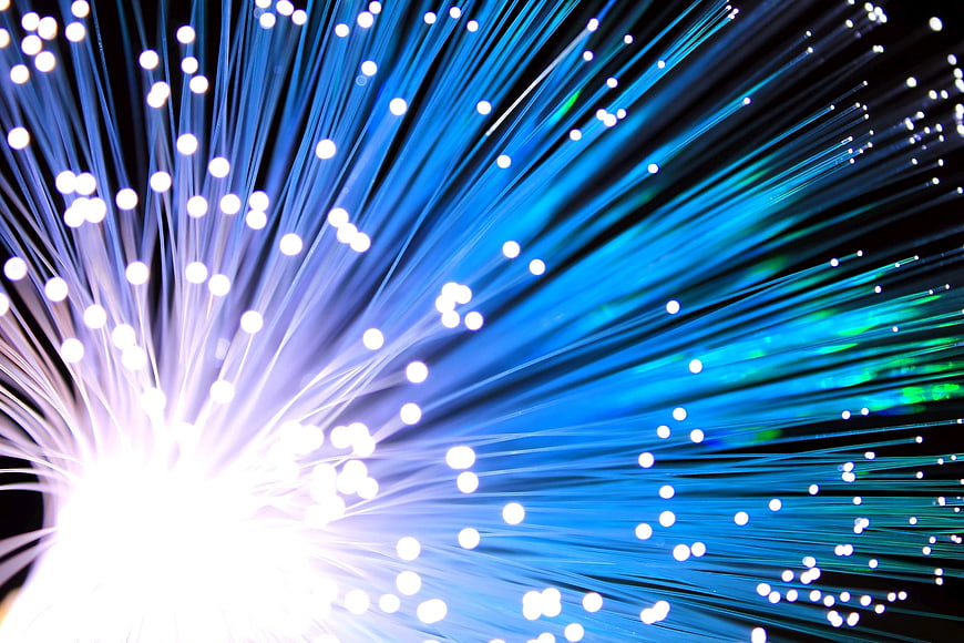 Blue Fiber Optic Cables Radiating Light on Black Background