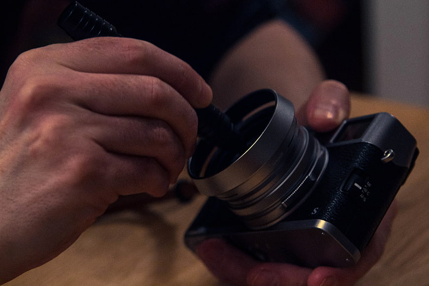 Close-up of hands cleaning vintage camera lens