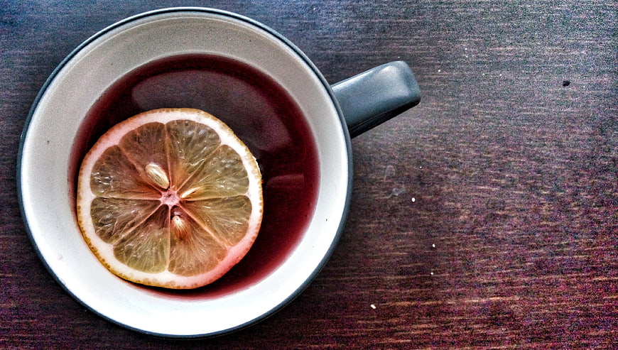 Top view of hot tea with lemon slice in ceramic mug