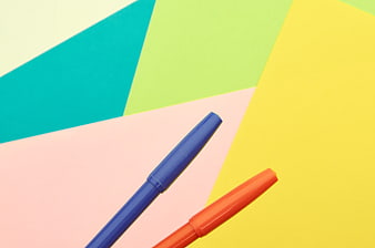 Blue and Orange Markers on Colorful Geometric Background