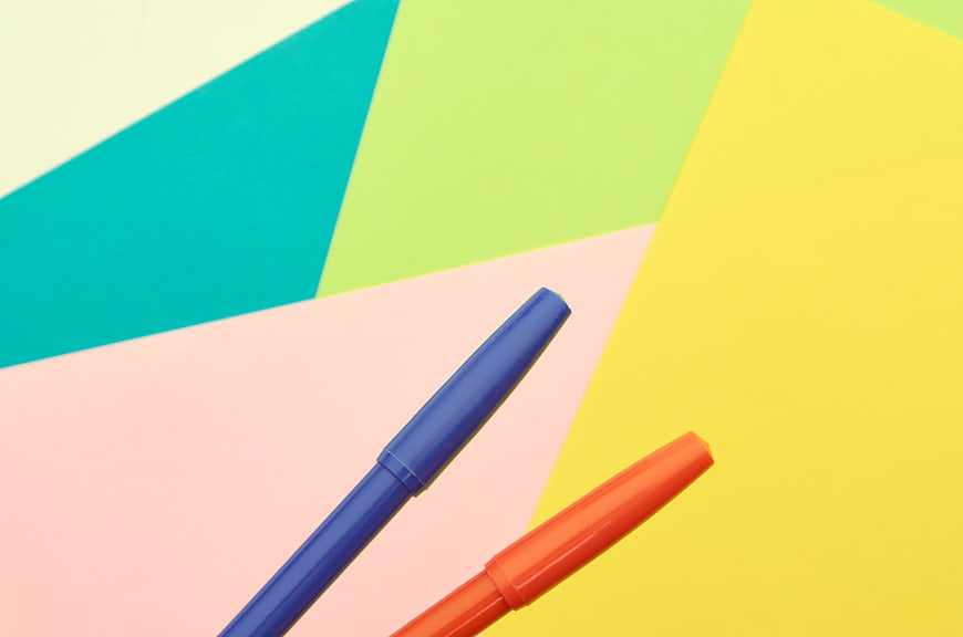Blue and Orange Markers on Colorful Geometric Background