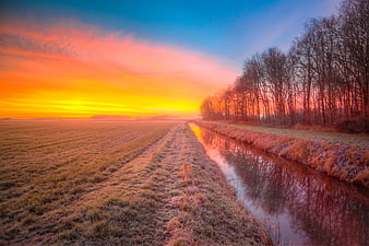 Frosty Canal Landscape with Vibrant Sunrise Sky