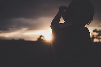 Silhouette of Woman Looking at Sunset Sky