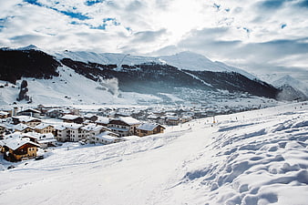 Snowy Alpine Village with Ski Slopes and Mountain Peaks