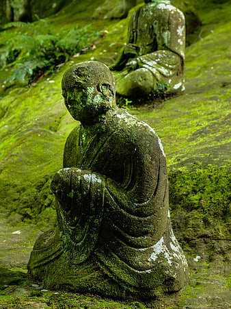 Moss-covered stone statues in a serene Japanese garden