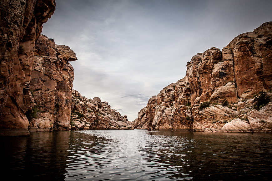 Dramatic Canyon River Landscape With Rocky Cliffs And Calm Water