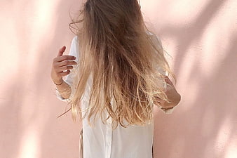 Woman with Long Blonde Hair Against Pink Wall