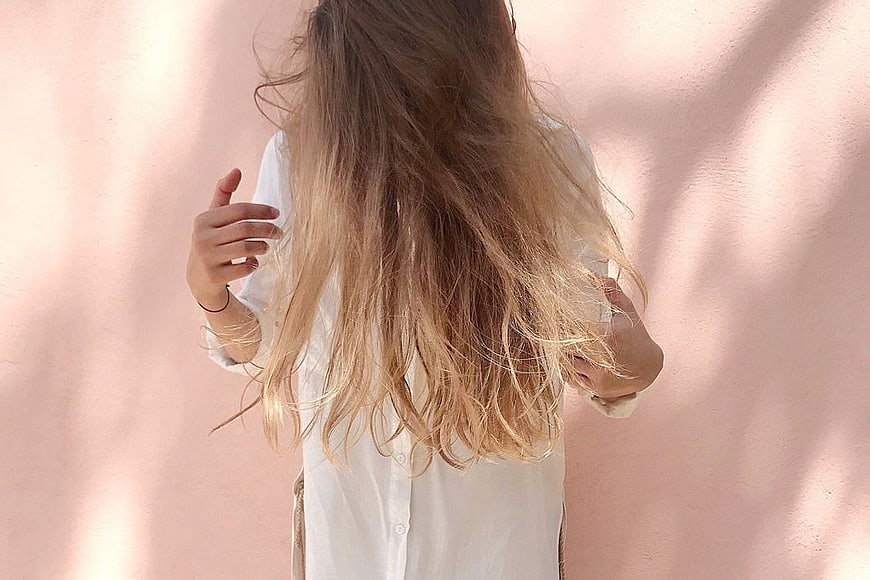 Woman with Long Blonde Hair Against Pink Wall