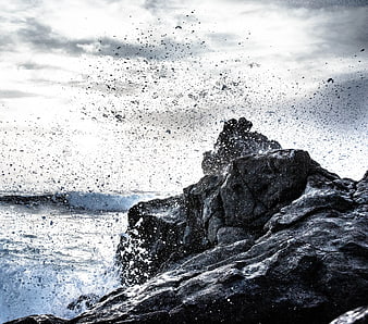 Dramatic Ocean Waves Crashing Against Dark Rocky Cliff