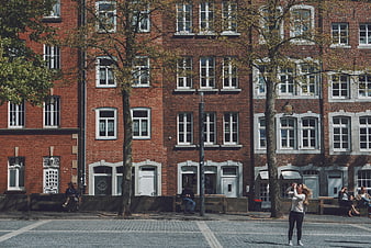 Woman taking photo in front of red brick architecture