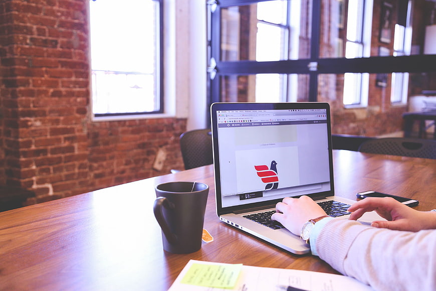 Person typing on laptop in modern office workspace
