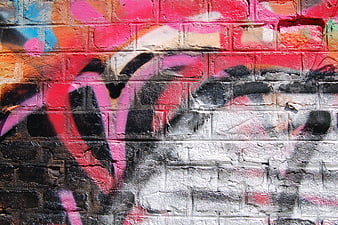 Colorful graffiti art on textured brick wall background