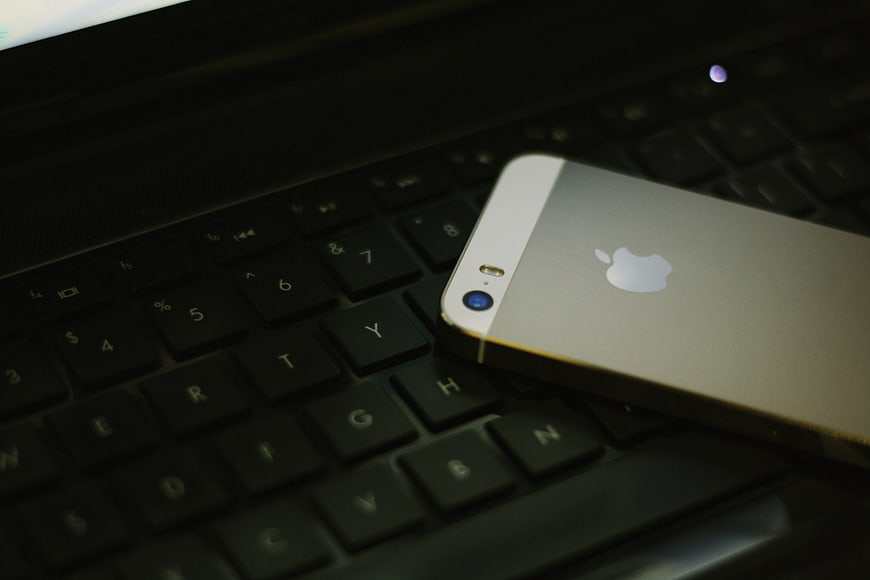 Silver Smartphone on Laptop Keyboard in Dark Setting