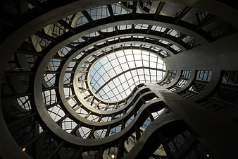Low angle view of modern spiral staircase with glass dome ceiling