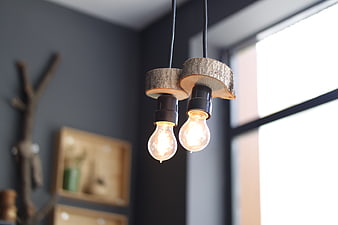 Rustic wooden pendant lights with glowing bulbs in modern interior