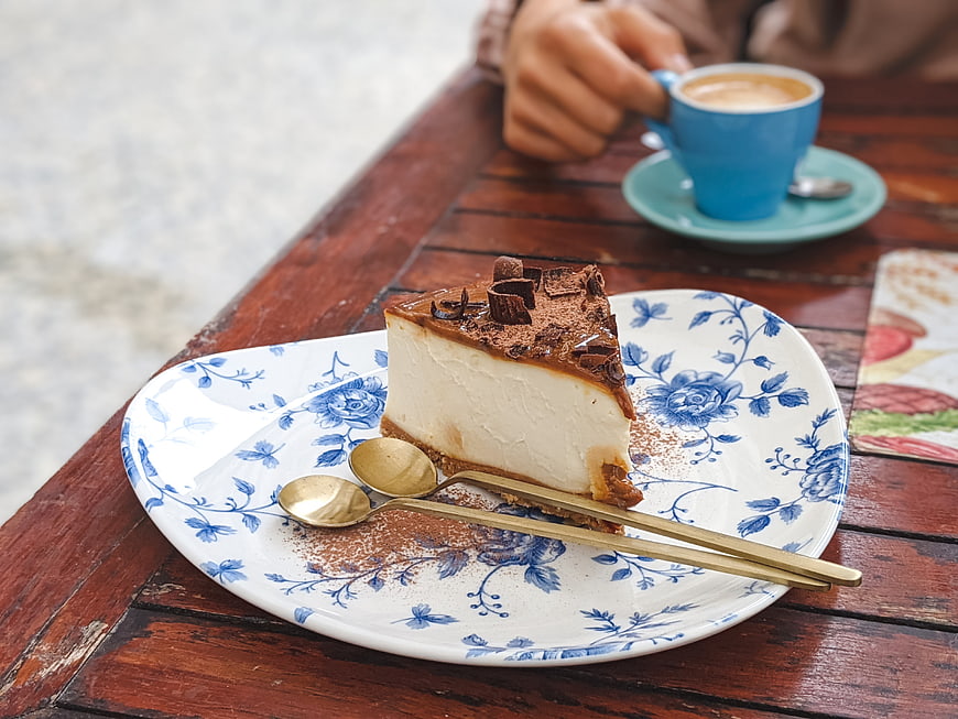 Slice of chocolate cheesecake with coffee on rustic wooden table