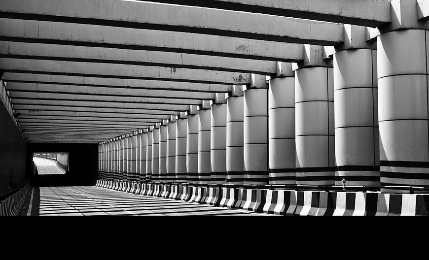 Black and White Concrete Tunnel with Rhythmic Pillars