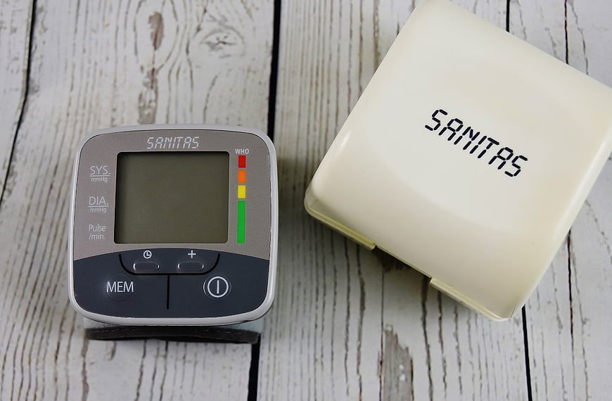 Digital Blood Pressure Monitor on White Wooden Background