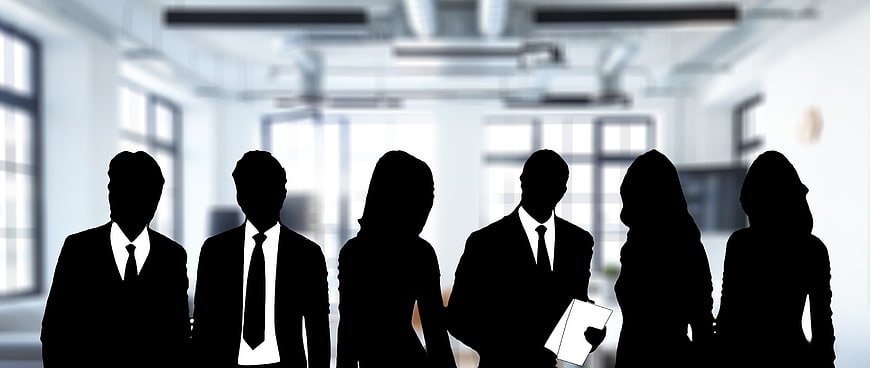 Silhouettes of business team in modern office background
