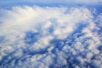 Aerial View of Fluffy White Clouds Against Blue Sky